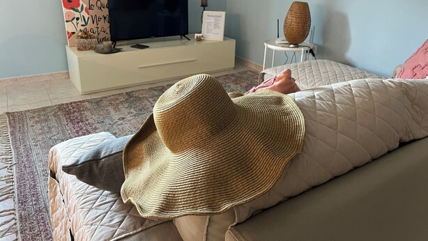 A bedroom with a bed, a television, a decorative wall piece, and a woven basket on a side table. - "Home from Home" with outdoor spaces for eating and relaxing, 5 minutes from the sea. (Tortoreto)
