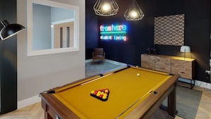 A pool table with balls, a neon sign, a chair, and a cabinet. - Cork Street in Dublin (Dublin)
