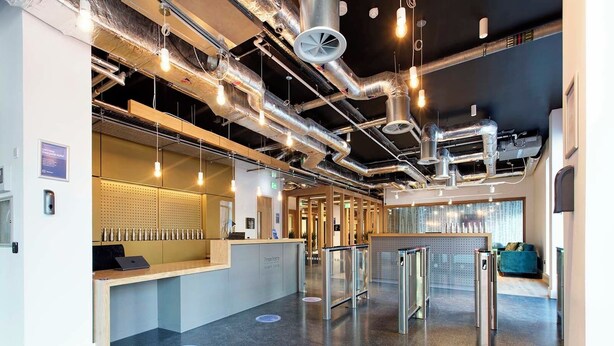 A modern reception area with a counter, turnstiles, and exposed ductwork. - Cork Street in Dublin (Dublin)