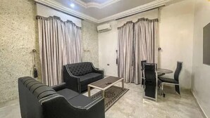 Un salon comprenant un canapé, une table basse et un coin repas avec une table et des chaises.