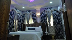 Une chambre à coucher avec un grand lit, un lustre et des rideaux.