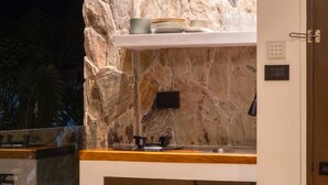 A modern bathroom with a stone wall, a sink, and a towel rack.