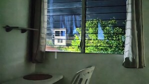 A small room with a window, a chair, and a table. - Single Room  (Santa Ana)