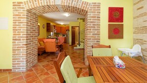 Un espace repas agrémenté d’une arche en briques, d’une table en bois et de chaises.