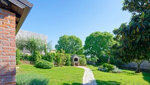 Un jardin avec un sentier de pierres menant à un bâtiment en briques.