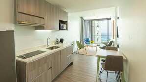 Una cuina moderna amb forn integrat, un rentapeus i una zona de menjador amb taula i cadires.
