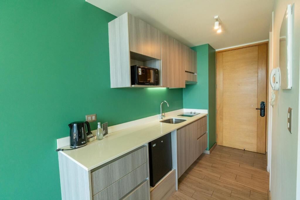 A compact kitchen with a microwave, sink, and cabinets.
