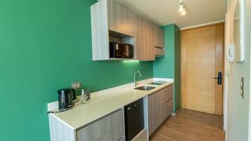 A compact kitchen with a microwave, sink, and cabinets.