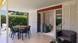 An outdoor patio with a dining table, chairs, and a sofa.