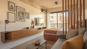 Un salon moderne comprenant un canapé, une table basse, un téléviseur et un meuble en bois.