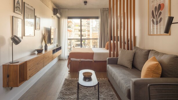 Un salon moderne avec un canapé, une table basse et un téléviseur posé sur un meuble en bois.