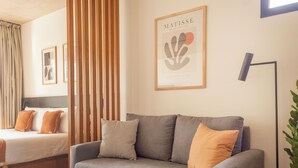Un salon moderne avec un canapé gris, une petite table ronde et un lampadaire.