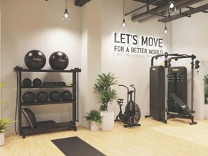 A gym with exercise equipment, a wall with motivational text, and potted plants. - Foundry Courtyard by UTDM (Glasgow)
