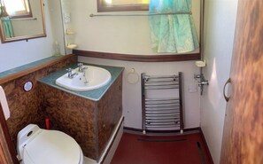 A compact bathroom with a sink, toilet, and towel rack. - Stone - Boat - Sleeps 4 - Pet Friendly-85ws (Stone)