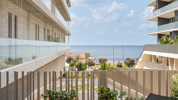Un edificio moderno con balcones con vistas a la playa.