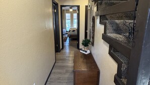 A hallway with a wooden bench, a fire extinguisher, and a staircase. - Newly Renovated 5 bedroom Condo in Ruidoso (Ruidoso)