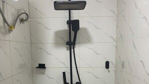 Een douche met een handdouche en een handscrubber.