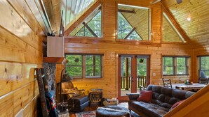 A cozy cabin interior with a wooden interior, a fireplace, a sofa, and a dining area. - Stunning  chalet close to Murphy. Hot Tub, Fire Pit, Dog Friendly, Ample Parking (Murphy)