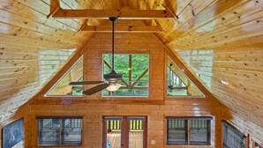 A high-ceilinged wooden cabin with a central fan, large windows, and a view of the forest. - Stunning  chalet close to Murphy. Hot Tub, Fire Pit, Dog Friendly, Ample Parking (Murphy)