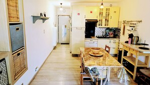 Une cuisine avec une table à manger, des chaises et un plancher en bois.