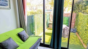 Une chambre avec un lit, une fenêtre et une vue sur un jardin.