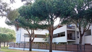 A modern two-story building with balconies and a fenced courtyard.