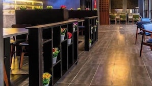 Un interior moderno con una zona de bar, asientos e iluminación decorativa.