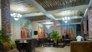 Un vestíbulo con suelo de baldosas, varias zonas de estar y pinturas decorativas en las paredes.
