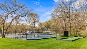 Un parc doté d’un court de tennis, d’un kiosque et d’une pelouse verdoyante.