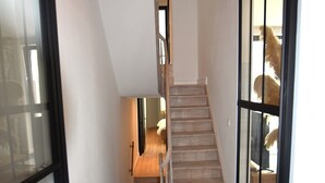 Un escalier en bois avec une porte en verre sur le côté droit, qui mène à une autre pièce.