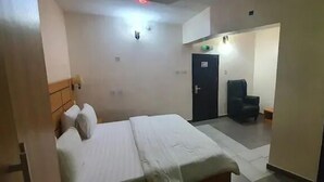 Ein Hotelzimmer mit einem Bett, einem Sessel und einer Tür.