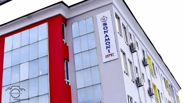 Ein Hotelgebäude mit roter und weißer Fassade, zahlreichen Fenstern und einem Schild mit der Aufschrift "SONAMONI HOTEL".