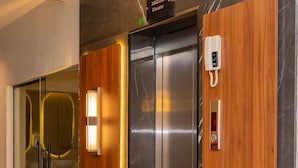 An elevator with a wooden panel and a phone. - Royal Palace Compound (Riyadh)