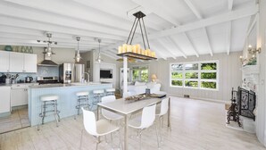 A spacious kitchen with a central island, bar stools, and pendant lighting.