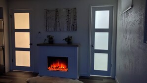 Ein Zimmer mit Kamin, zwei Türen und einem an der Wand befestigten Kunstwerk.