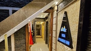 A hotel entrance with a stone wall, a sign for 'VIDA Pyramids Inn', and a staircase leading to upper floors. - Vida Pyramids Inn (Giza)