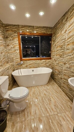 Habitación triple Deluxe | Baño | Cabezal de ducha tipo lluvia, secador de pelo, zapatillas y bidé