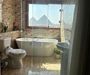 Deluxe Triple Room | Bathroom | Separate bathtub and shower, rainfall showerhead, hair dryer, slippers - Vida Pyramids Inn (Giza)