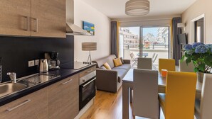 Eine moderne Küche mit Backofen und Essbereich, inklusive Tisch und Stühlen.
