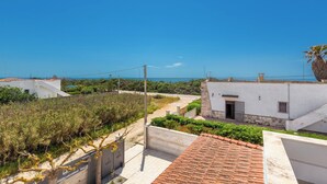 A coastal residential area with white buildings, a tiled roof, and a clear blue sky. - Villa Metta  by BarbarHouse (San Pietro in Bevagna)