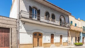A two-story building with a balcony, wooden doors, and a sign that reads "DHome". - D.Home B&B - Camera quadrupla (Oria)