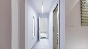 A narrow hallway with white walls and a tiled floor. - D.Home B&B - Camera quadrupla (Oria)