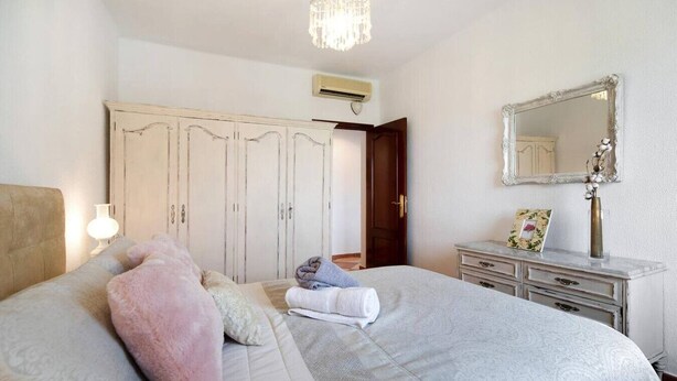 A bedroom with a bed, a dresser, a mirror, and a wardrobe. - Grand Beachside Apartment (Cádiz)