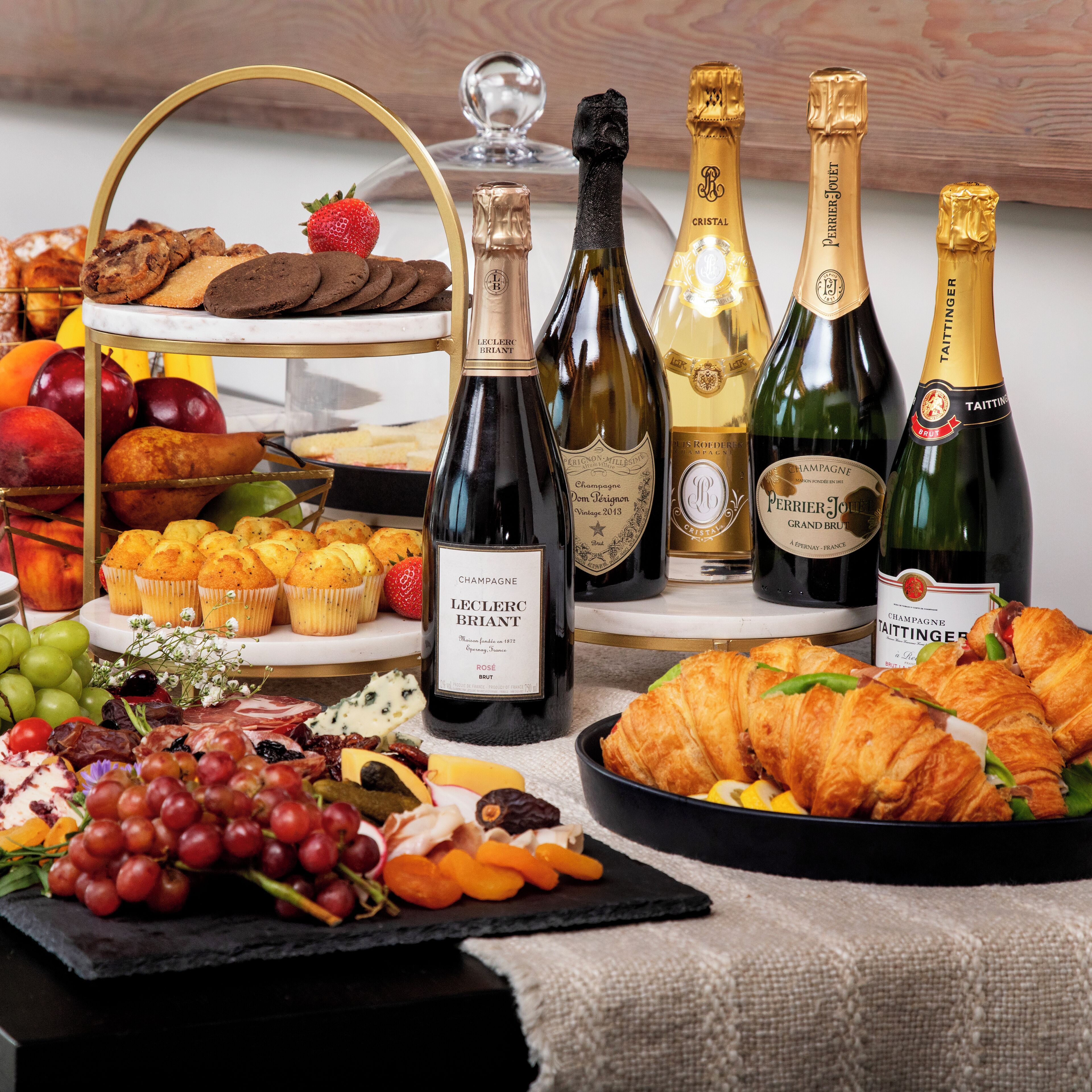 A variety of food items and champagne bottles on a table.