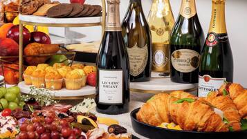 A variety of food items and champagne bottles on a table.