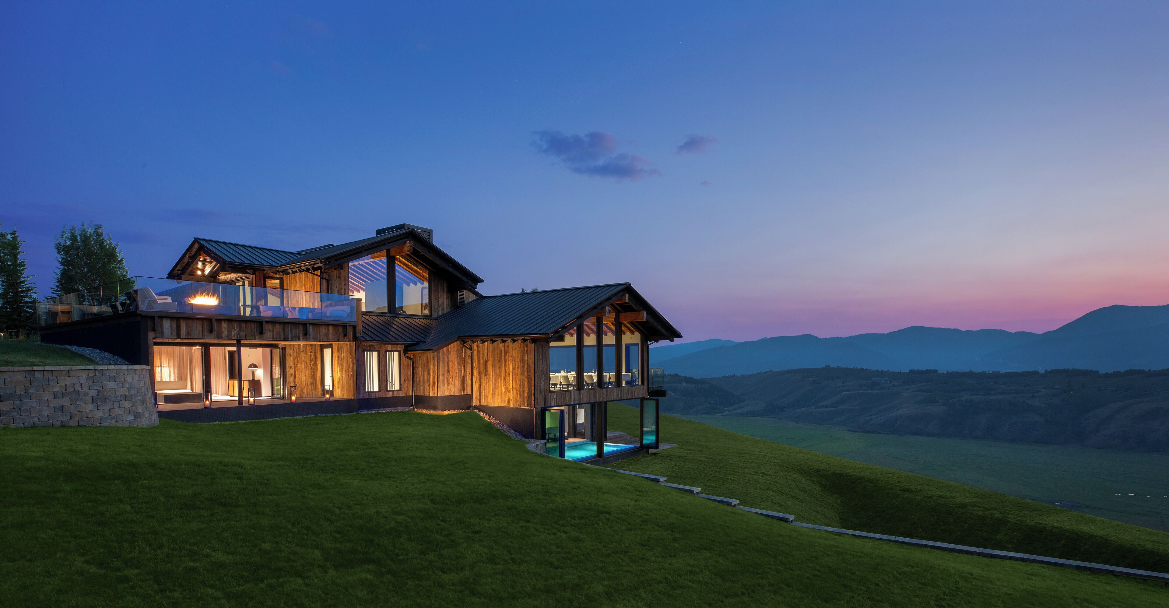 A modern house with a large deck and a swimming pool.
