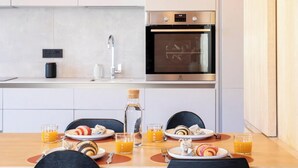 Une cuisine moderne dotée d’un four encastré et d’une hotte en acier inoxydable.