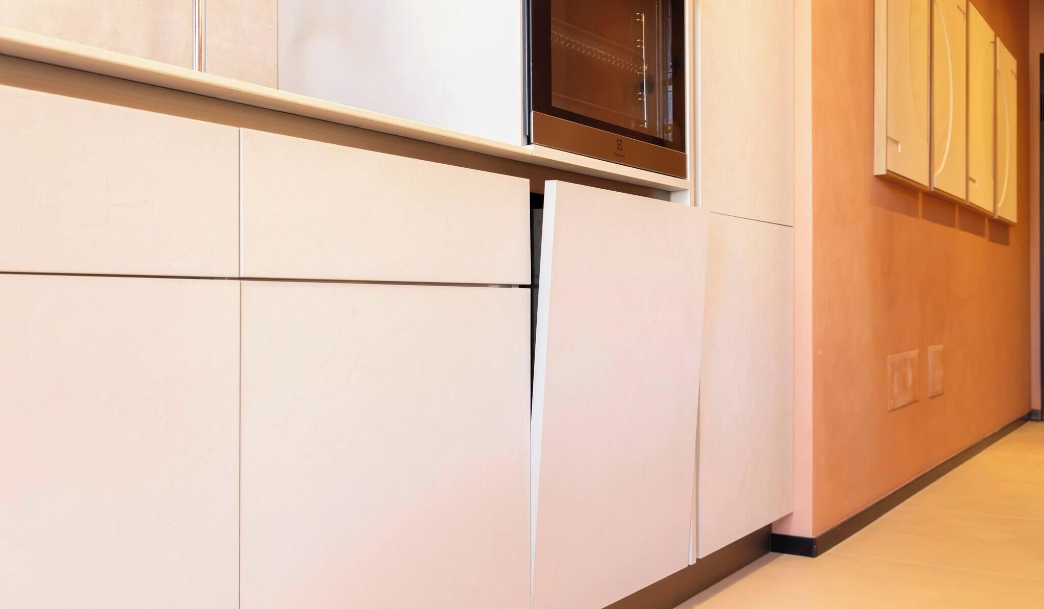 Une cuisine moderne avec des meubles blancs et un four en acier inoxydable.