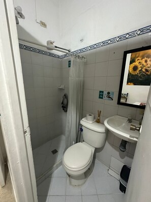 Economy kamer | Badkamer | Een douche, handdoeken, zeep, toiletpapier