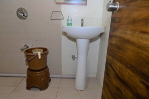 A bathroom with a toilet, sink, and a wooden door.